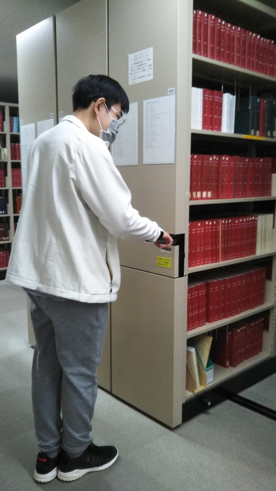 図書館で棚の使い方を確認するアシタさん